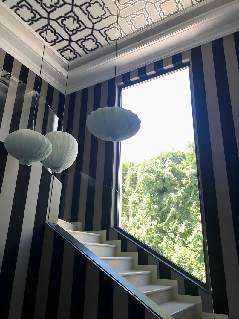 La cage d’escalier aux murs rayés et aux lanternes en papier