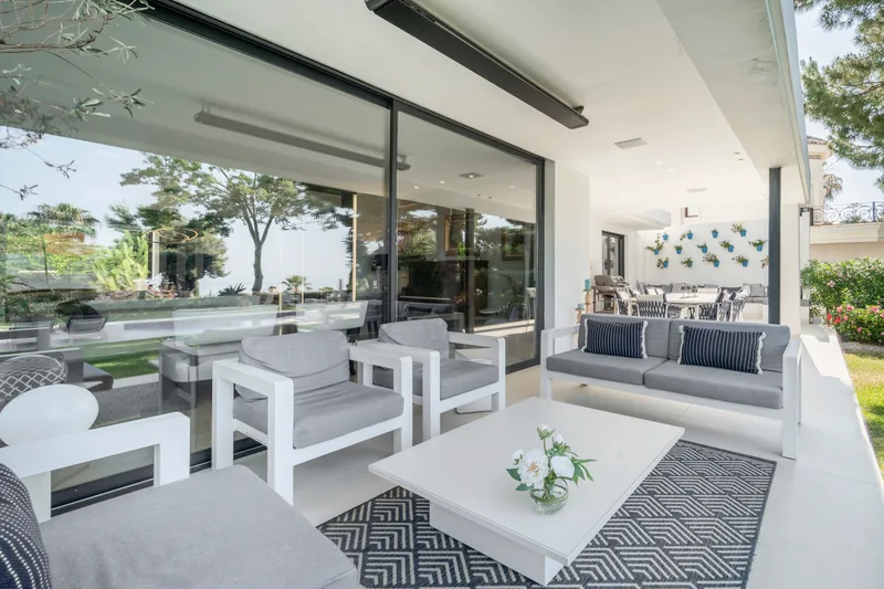 Salon de la terrasse couverte avec chauffages au plafond, vue le long de la terrasse